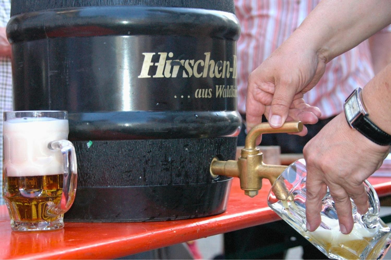 Eine Person zapft sich ein Bier aus einem Bierfass.